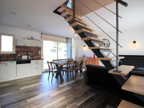 a kitchen and dining room with a spiral staircase in a house at Maison La Bourboule, 3 pièces, 8 personnes - FR-1-608-203 in La Bourboule