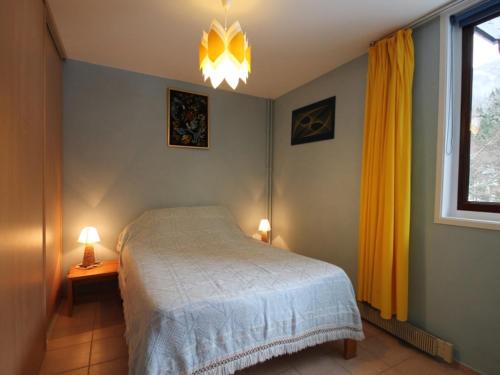 - une chambre avec un lit, une fenêtre et 2 lampes dans l'établissement Charmant T2 avec Balcon et Wi-Fi au Mont-Dore, Proche Centre et Thermes - FR-1-608-193, à Le Mont-Dore