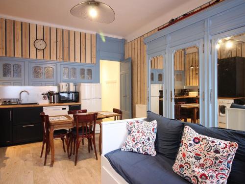 un salon et une cuisine avec un canapé et une table dans l'établissement Mont-Dore : Charmant T2 à 100m du marché avec WIFI au pied du Puy de Sancy - FR-1-608-197, à Le Mont-Dore