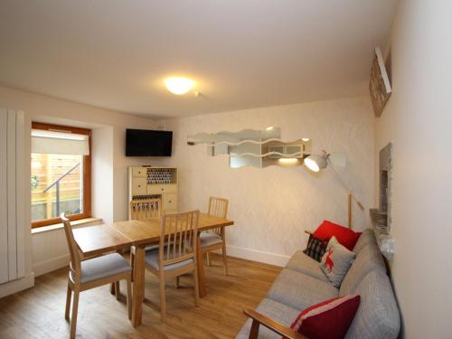 - un salon et une salle à manger avec une table et un canapé dans l'établissement Le Mont-Dore : Appartement 3 pièces avec terrasse et WIFI à 300m des Thermes - FR-1-608-204, à Le Mont-Dore