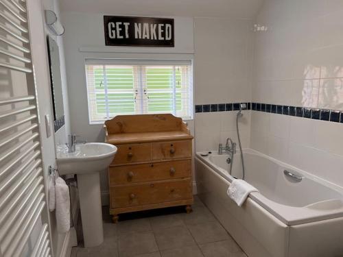 a bathroom with a sink and a tub and a sign that says get maker at Grange Farm in Lincolnshire