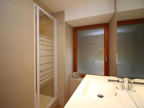 une salle de bain avec un lavabo et un miroir dans l'établissement Le Mont-Dore : Appartement 3 pièces avec terrasse et WIFI à 300m des Thermes - FR-1-608-204, à Le Mont-Dore