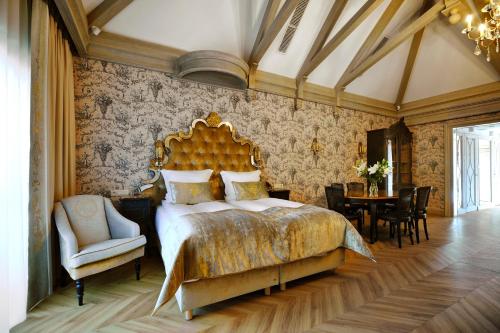 sypialnia z dużym łóżkiem, stołem i krzesłami w obiekcie Złota Łania Wiartel Resort & SPA w mieście Wiartel