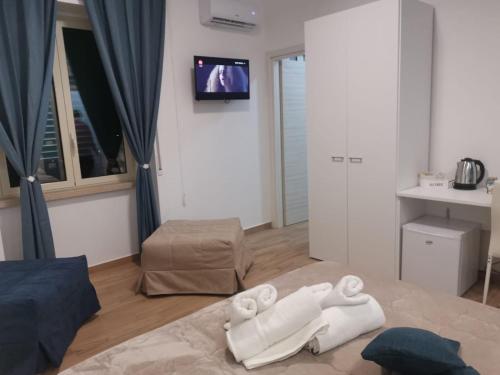 - un salon avec des serviettes blanches sur un lit dans l'établissement G&G Home, à Cosenza
