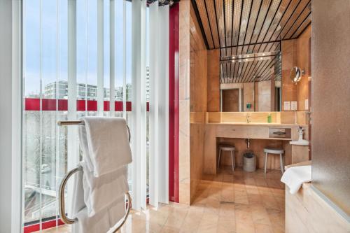 a bathroom with a large window and a sink at becozy Au Parc Retro Edition Self-Check-In Rooms & Studios Fribourg in Fribourg