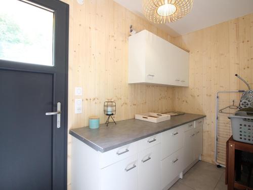 a kitchen with white cabinets and a black door at Chalet Mont-Dore, 5 pièces, 10 personnes - FR-1-608-206 in Le Mont-Dore