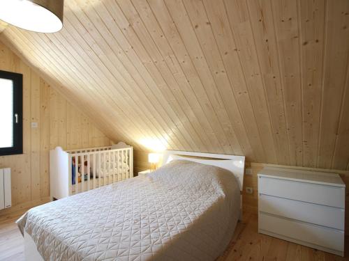 - une chambre avec un lit blanc au plafond en bois dans l'établissement Chalet moderne 92m² avec garage, bornes de recharge, Wi-Fi, proche du centre - FR-1-608-206, à Le Mont-Dore