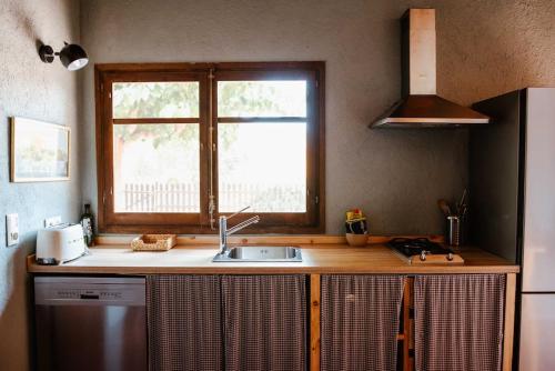 cocina con fregadero y ventana en La Viña. Casa rural en el campo, en Tordera