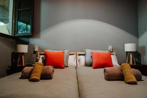 una cama con almohadas coloridas encima en La Viña. Casa rural en el campo, en Tordera