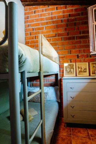 a bedroom with two bunk beds and a brick wall at La Viña. Casa rural en el campo in Tordera