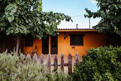 an orange house with a fence in front of it at La Viña. Casa rural en el campo in Tordera