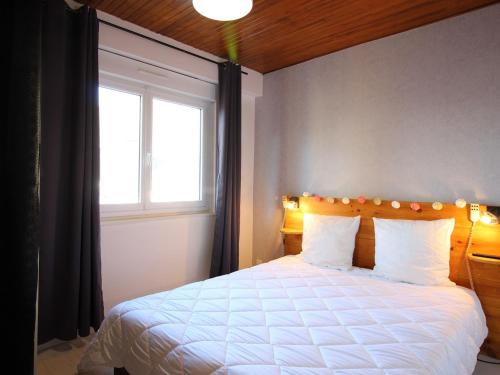 une chambre avec un lit blanc avec une fenêtre dans l'établissement Superbe T2 au centre du Mont-Dore avec wifi, proche Thermes et navette ski - FR-1-608-216, à Le Mont-Dore