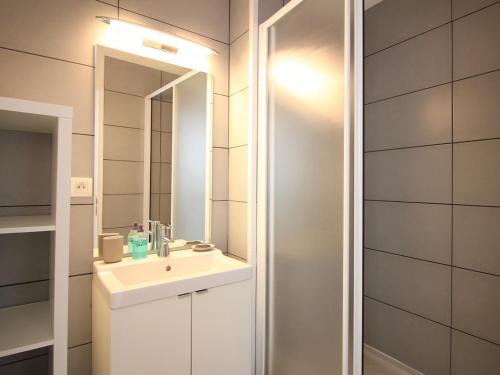 ein Badezimmer mit Waschbecken und Spiegel in der Unterkunft Charmant Duplex T3 avec Wifi au Centre de Mont-Dore, proche Thermes et Navette Ski Gratuite - FR-1-608-217 in Le Mont-Dore