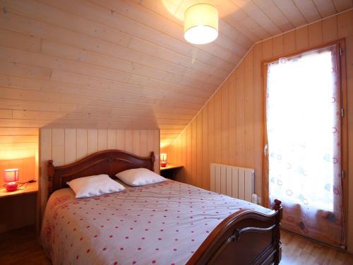 a bedroom with a bed in a room with a window at Beau chalet 4 chambres, terrasse, garage, WiFi au Mont-Dore - FR-1-608-223 in Le Mont-Dore