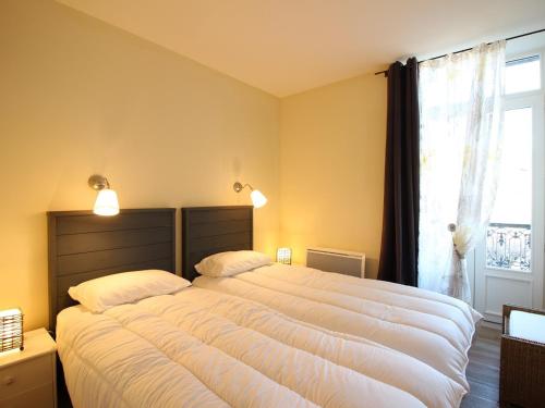 une chambre avec deux lits et une fenêtre dans l'établissement Appartement T3 de Standing avec Balcon et Parking au Centre de La Bourboule - FR-1-608-226, à La Bourboule