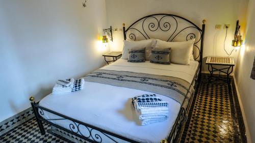 a bedroom with a large bed with white sheets and pillows at Riad Green House in Fès