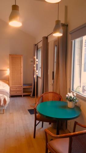 - un salon avec une table verte et un lit dans l'établissement Maisonnette cosy cœur centre avec accueil vélo, à Saumur