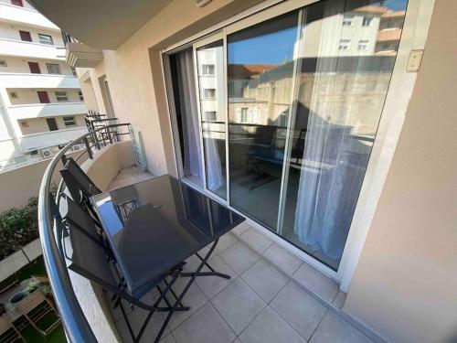 a balcony with a table and chairs on a balcony at Appartement Centre Ville Sainte-Maxime Tout à Pied in Sainte-Maxime