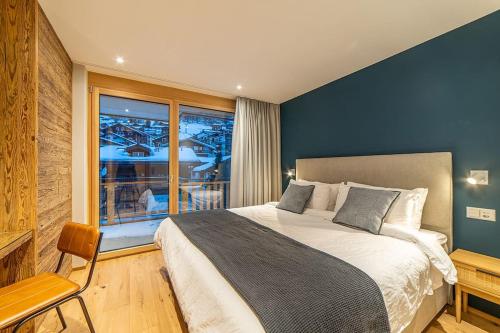 a bedroom with a large bed and a window at Saas-Fee stylish ski apartment in Saas-Fee