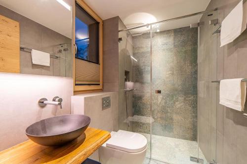 a bathroom with a sink and a glass shower at Saas-Fee stylish ski apartment in Saas-Fee