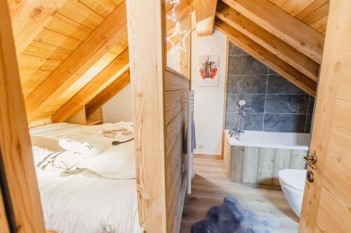 a bedroom with a bed and a tub in a room at Les Loups Blancs, duplex rénové en 2022, pied des pistes in Montgenèvre