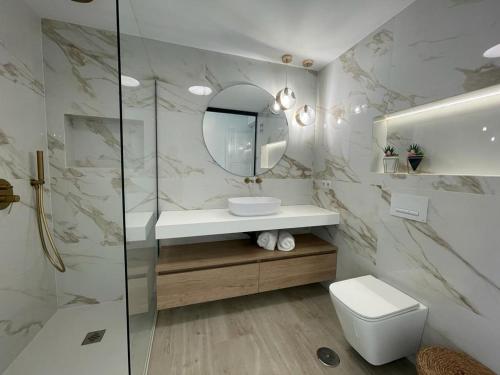 La salle de bains est pourvue de toilettes, d'un lavabo et d'un miroir. dans l'établissement Piso en Fuengirola Castillo Sohail, à Fuengirola