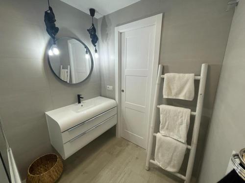 a white bathroom with a sink and a mirror at Piso en Fuengirola Castillo Sohail in Fuengirola