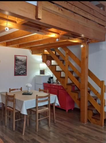 une salle à manger avec une table et un escalier dans l'établissement Jean marc, à Luchon