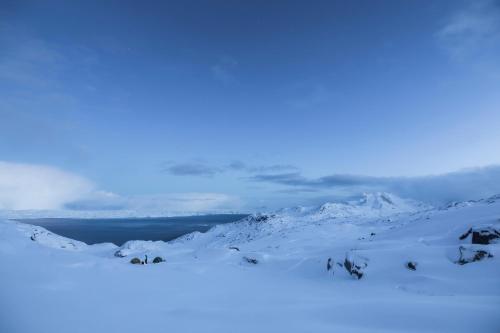 a snow covered mountain with clouds in the background at Hotel Hans Egede in Nuuk