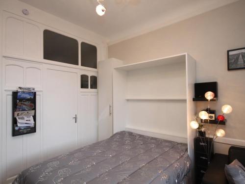 une chambre avec un lit et une étagère dans l'établissement Studio rénové avec balcon, tout confort et Wi-Fi au centre de Mont-Dore - FR-1-608-105, à Le Mont-Dore