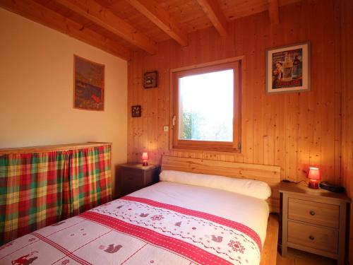 een slaapkamer met een bed en een raam in een hut bij Chalet Mont-Dore, 5 pièces, 8 personnes - FR-1-608-106 in Le Mont-Dore