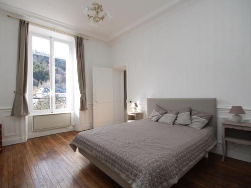 une chambre blanche avec un lit et une fenêtre dans l'établissement Appartement lumineux T2 avec kitchenette équipée, lave-linge et ascenseur - FR-1-608-108, à Le Mont-Dore