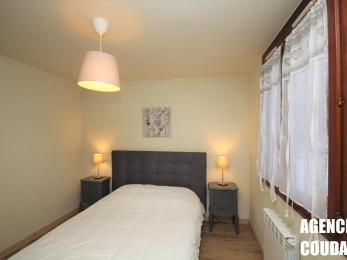 a bedroom with a bed with two night stands and two lamps at Appartement Mont-Dore, 2 pièces, 4 personnes - FR-1-608-114 in Le Mont-Dore