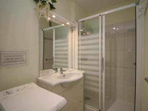 ein weißes Badezimmer mit Dusche und Waschbecken in der Unterkunft Appartement 2 pièces avec balcon, parking et WiFi - 4 personnes - FR-1-608-117 in Le Mont-Dore