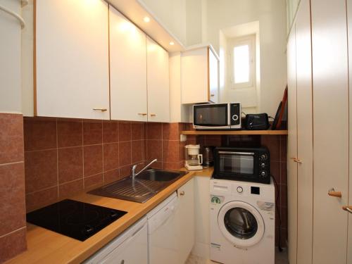 une cuisine avec un lave-linge et un micro-ondes dans l'établissement Mont-Dore: T2 cosy avec vue sur la montagne, proche centre-ville, 4 pers, animaux non admis - FR-1-608-115, à Le Mont-Dore