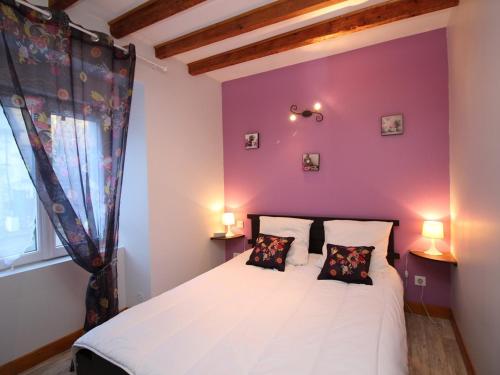 une chambre avec un lit blanc avec un mur violet dans l'établissement T3 à La Bourboule, terrasse, wifi, proche centre et thermes - FR-1-608-128, à La Bourboule