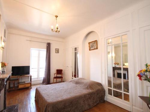 une chambre avec un lit, un bureau et une télévision dans l'établissement Mont-Dore : Beau T2 Hyper Centre avec Wifi - FR-1-608-126, à Le Mont-Dore