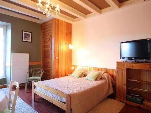 une chambre avec un lit et une télévision à écran plat dans l'établissement Studio Centre-Ville Mont-Dore, Résidence Historique, 2 Étoiles, Wifi & Confort pour 2 Personnes - FR-1-608-121, à Le Mont-Dore