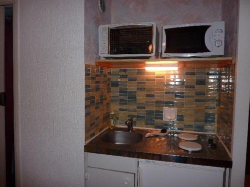 a kitchen with a sink and a microwave at Studio Mont-Dore, 1 pièce, 4 personnes - FR-1-608-122 in Le Mont-Dore