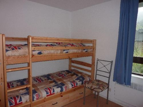 a bedroom with two bunk beds and a chair at Studio Mont-Dore, 1 pièce, 4 personnes - FR-1-608-122 in Le Mont-Dore