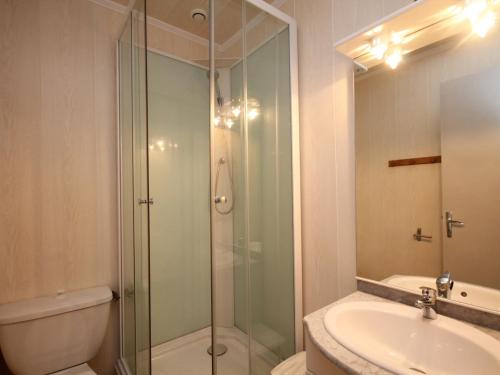 une salle de bain avec une douche en verre et un lavabo dans l'établissement Charmant T1 Mont-Dore, 400m des Thermes, équipé pour 4 pers. - FR-1-608-132, à Le Mont-Dore