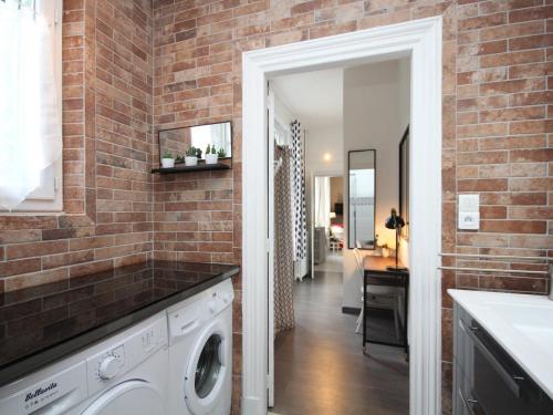 une buanderie en brique avec laveuse et sécheuse dans l'établissement Charmant T3 au Mont-Dore avec Balcon, à 100m du Centre et des Thermes - FR-1-608-155, à Le Mont-Dore