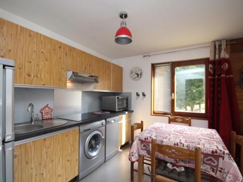 - une cuisine avec une table, un évier et un lave-linge dans l'établissement Appartement 2 pièces avec balcon au Mont-Dore, proche centre, parking, pour 4 personnes - FR-1-608-135, à Le Mont-Dore
