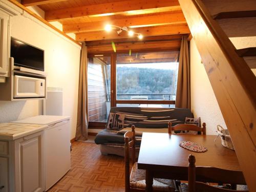 Il dispose d'une cuisine et d'un salon avec un canapé et une table. dans l'établissement Mont-Dore T2 Duplex, Balcon, 6 Pers, Équipé - FR-1-608-156, à Le Mont-Dore