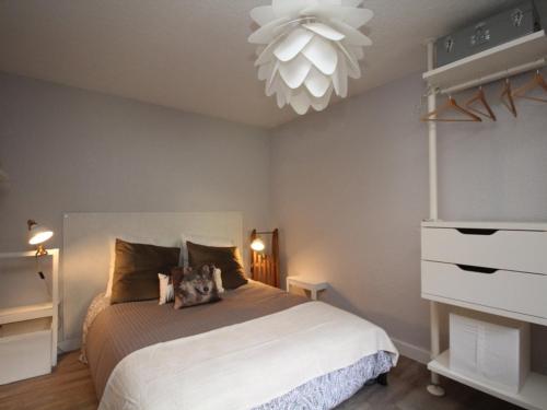 a bedroom with a bed and a chandelier at Appartement Mont-Dore, 2 pièces, 4 personnes - FR-1-608-142 in Le Mont-Dore