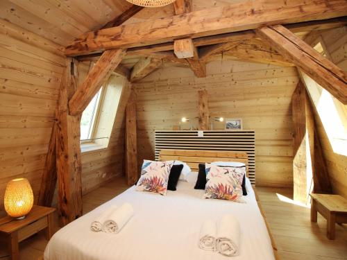 ein Schlafzimmer mit einem Bett in einer Blockhütte in der Unterkunft Charmant Duplex T3 au Mont-Dore, à 300m des Thermes, avec Parking et WiFi ! - FR-1-608-151 in Le Mont-Dore
