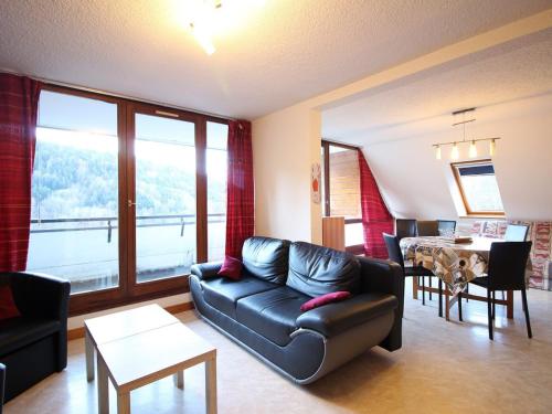 un salon avec un canapé et une table dans l'établissement Appartement T3 avec Terrasse et Parking Privé - Mont-Dore, Proche Centre et Thermes - FR-1-608-157, à Le Mont-Dore