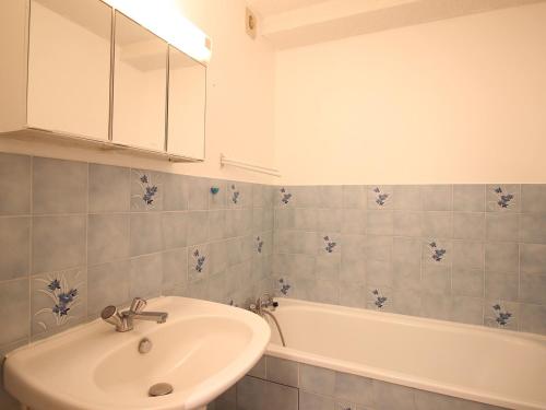 une salle de bain avec un lavabo et une baignoire dans l'établissement Appartement T3 avec Terrasse et Parking Privé - Mont-Dore, Proche Centre et Thermes - FR-1-608-157, à Le Mont-Dore