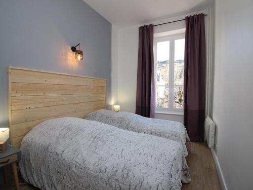 ein Schlafzimmer mit zwei Betten und einem Fenster in der Unterkunft LA BOURBOULE CENTRE - Beau T2 rénové, wifi et cuisine équipée - FR-1-608-159 in La Bourboule