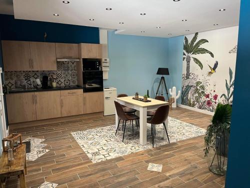 cocina con mesa y sillas en una habitación en La tropicale gite avec Spa 2-4 personnes, 